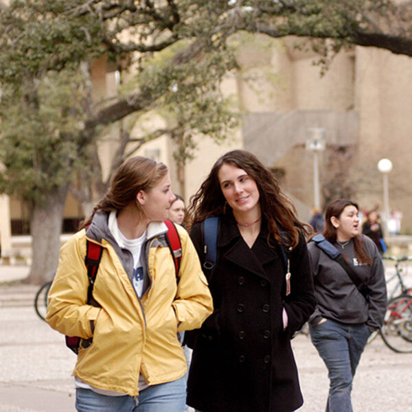 two female students walking in front of the College of Education and Human Development